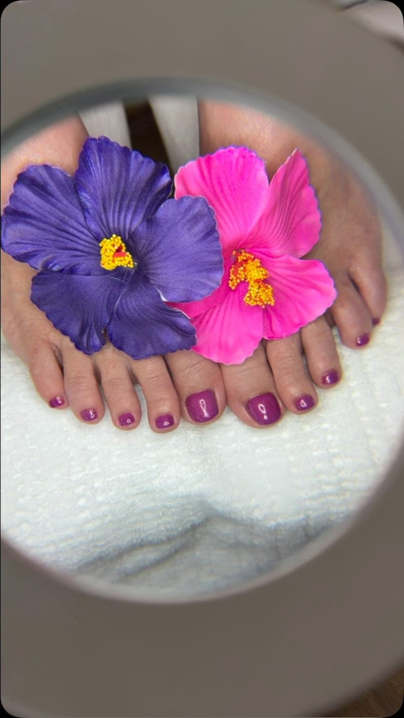Violette Shellac-Pediküre mit Blüten-Deko unter der Lupenlampe — Arbeit von Andrea
